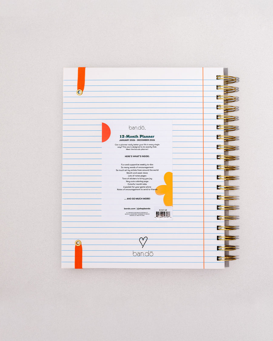 back view of white lined paper large 12-month planner with cursive 'ready for anything' font and orange elastic closure