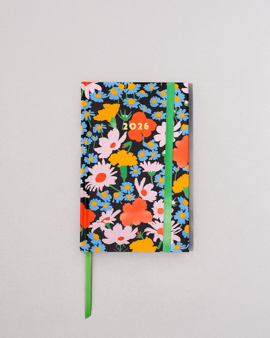black 12-month classic planner with green elastic closure and bookmark with all over colorful floral print
