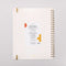 back view of cream large annual soft cover 12-month planner with colorful block lettered 'a work of art' typography with gold elastic closure