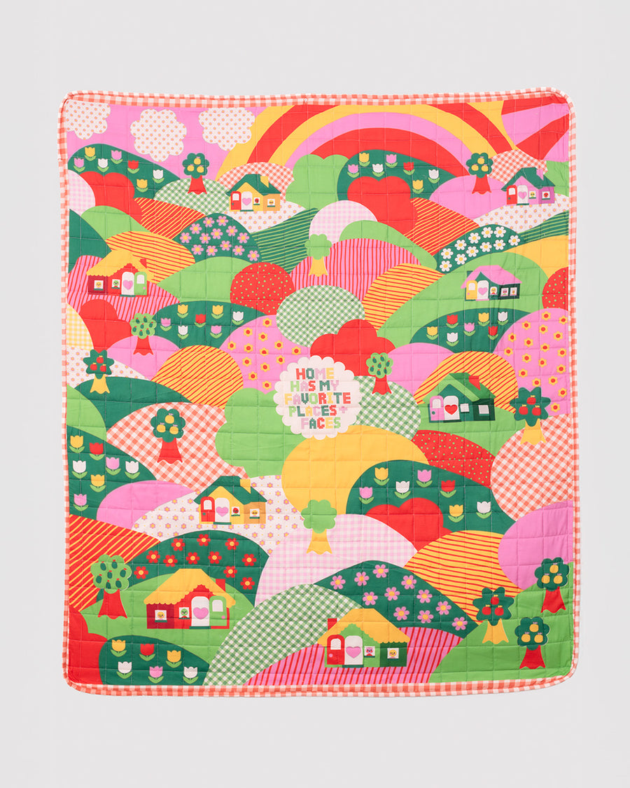 Quilted blanket with illustrated faces and places pattern.