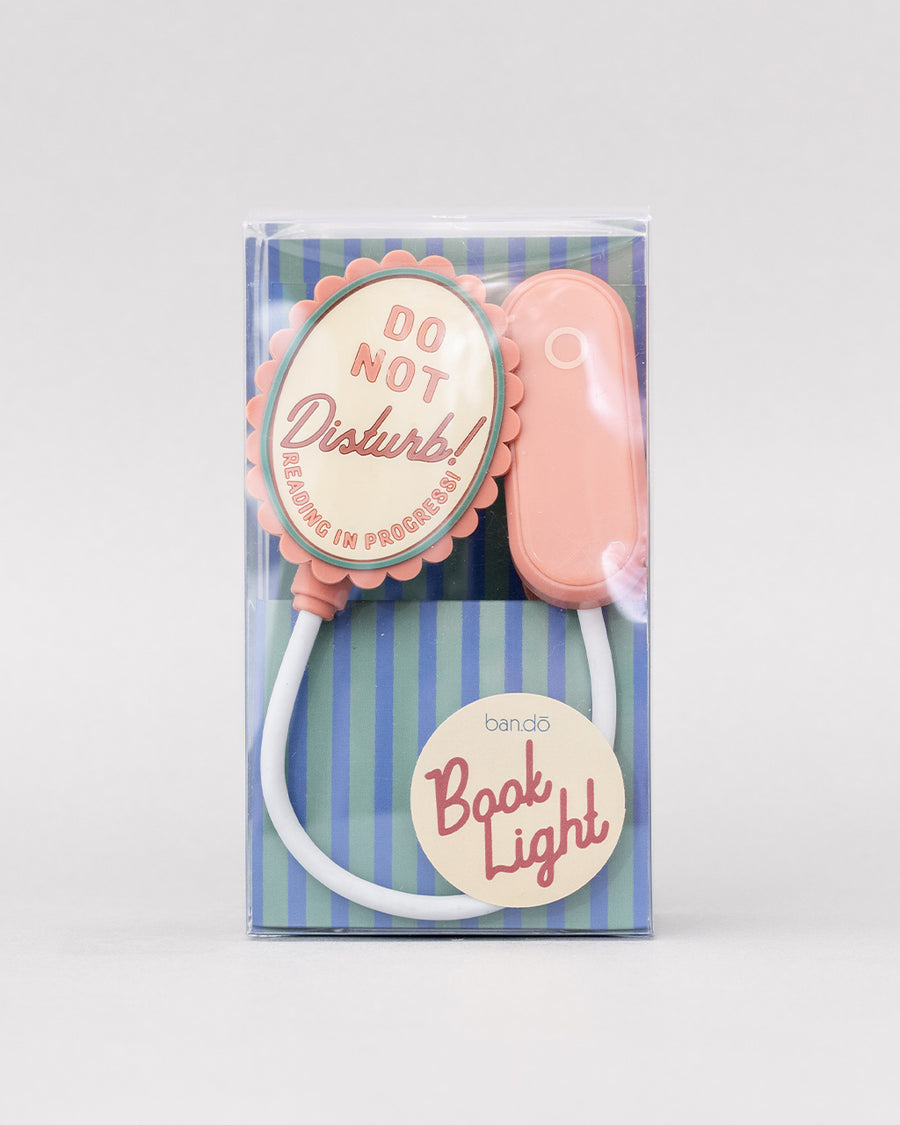 packaged pink book light with pink and cream 'do not disturb! reading in progress!' on the top of the light