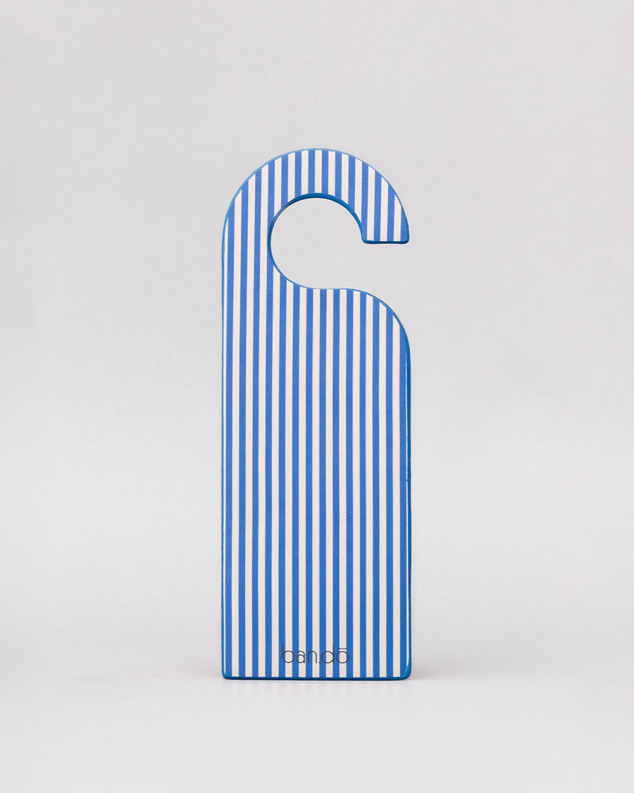 blue and white vertical stripe of blue bookmark in the shape of a door hanger with white 'do not disturb!i'm currently lost in a fantasy world and i don't want to leave!' across the front
