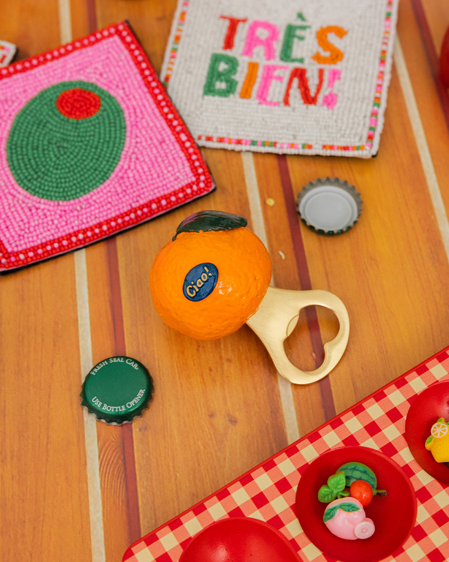 realistic orange clementine bottom opener surrounded by colorful coasters and bottle caps