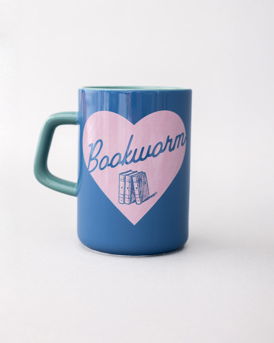 blue ceramic mug with light pink heart and cursive' bookworm' across the front with teal handle and interior