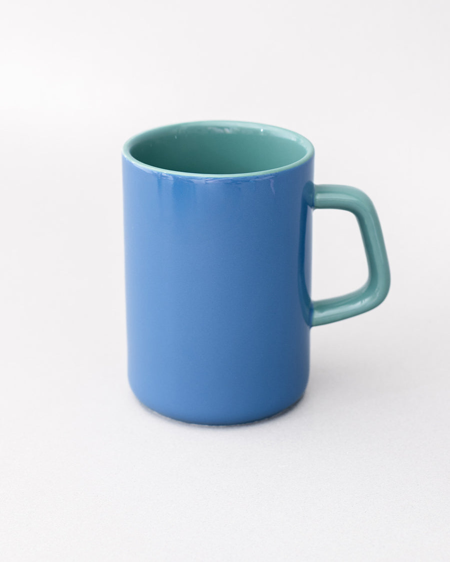 back view of blue ceramic mug with teal handle and interior