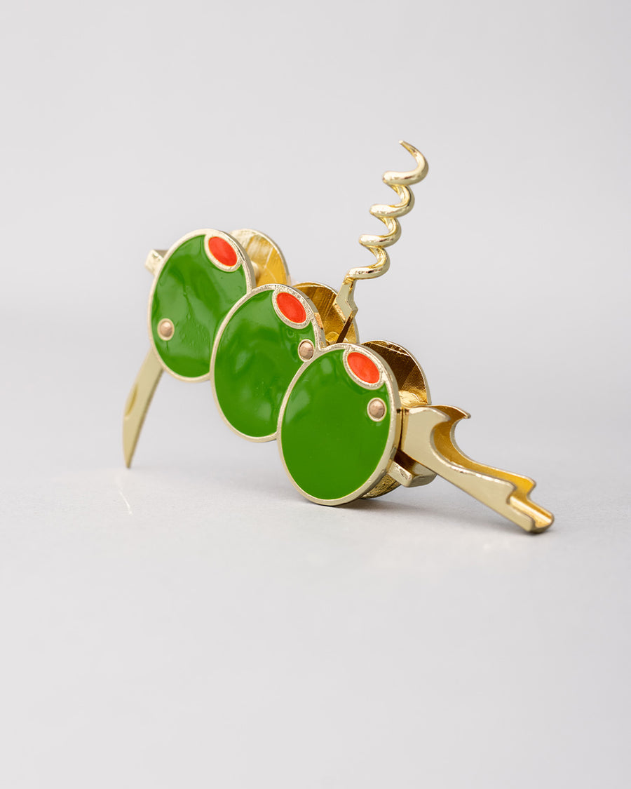 opened gold pocket corkscrew with three green olives