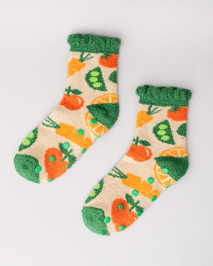 Pair of cozy socks with colorful veggie pattern and grip bottoms, shown on a light background.