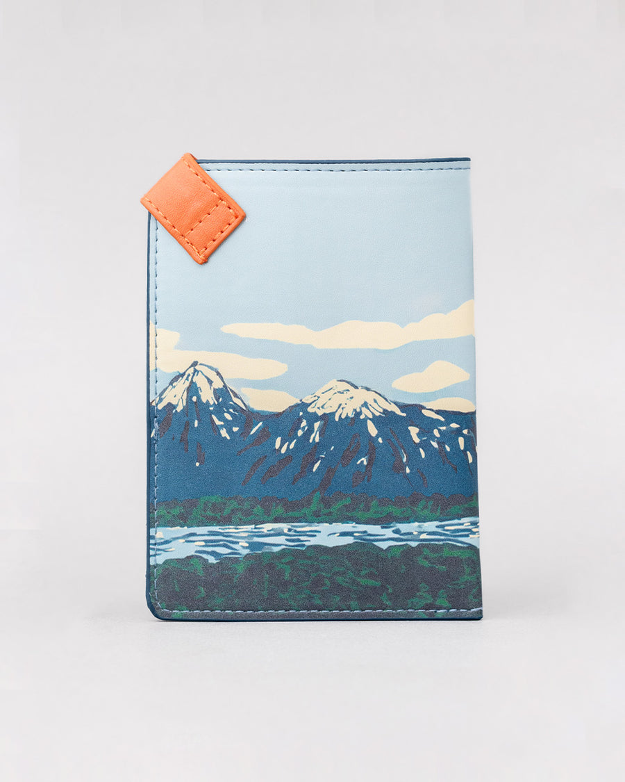 back view of passport holder with colorful mountain scene and 'greeting from paradise' across the front