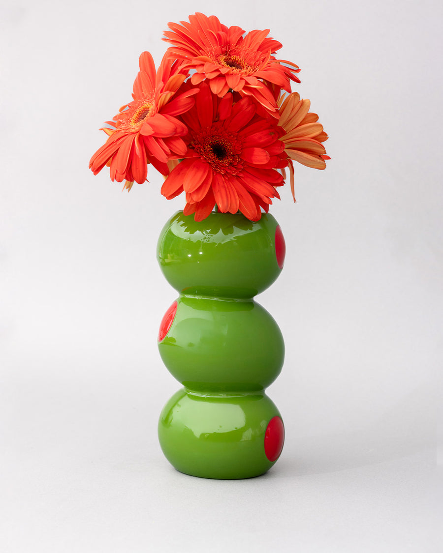 Ceramic vase with sculpted olive design inspired by classic martinis, styled with flowers on a bar cart.