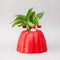 red jello mold vase/planter with a green plant inside