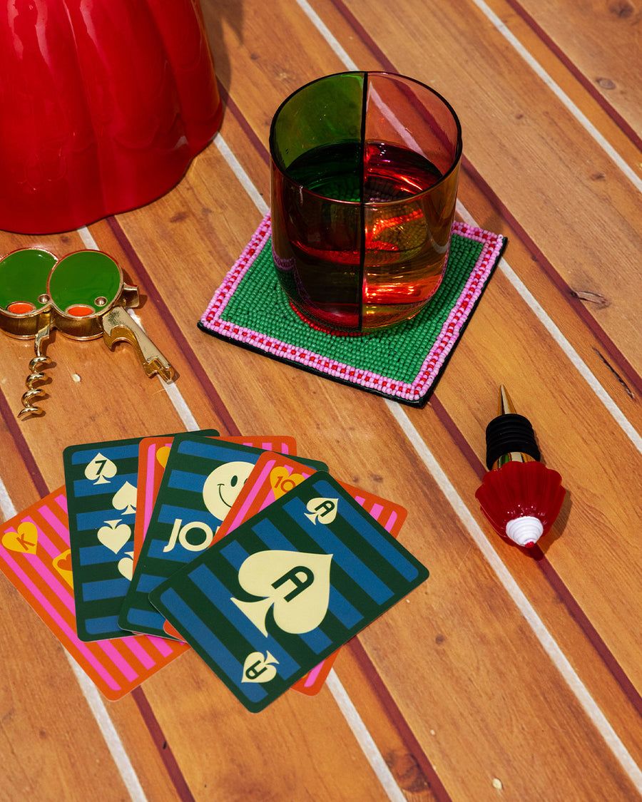 low ball glass set with four colors sections: pink, green, orange and red with playing cards near