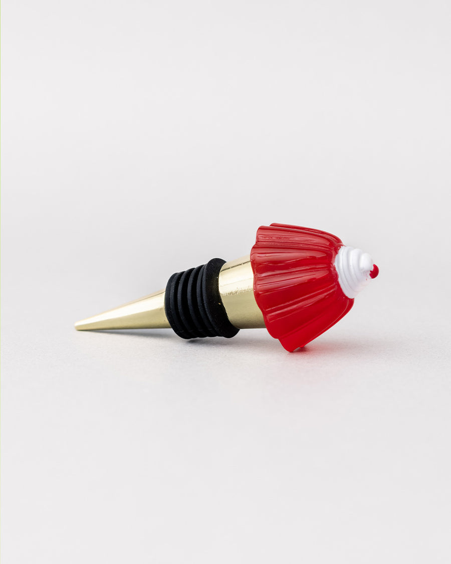 side view of gold brass wine stopper with red jello mold topper and black rubber stopper
