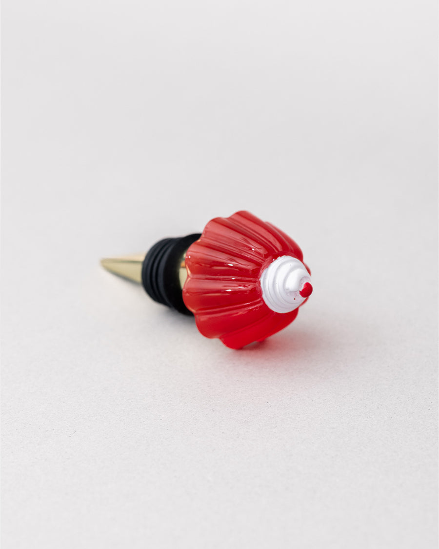 top view of gold brass wine stopper with red jello mold topper and black rubber stopper