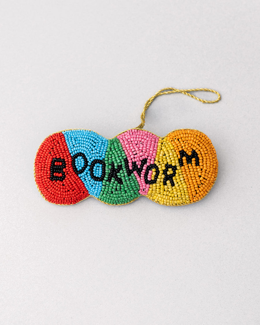 colorful beaded ornament with beaded 'bookworm' across the front with old thread for hanging