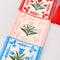 up close of red, pink and blue embroidered folk floral bookmark with red tassel top