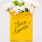 back view of yellow pasta box ceramic vase that says 'BUON APPETITO' with flowers inside 