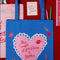 blue tote bag with pink heart and 'THE SMELL OF PASTRIES AND BOOKS' across the front