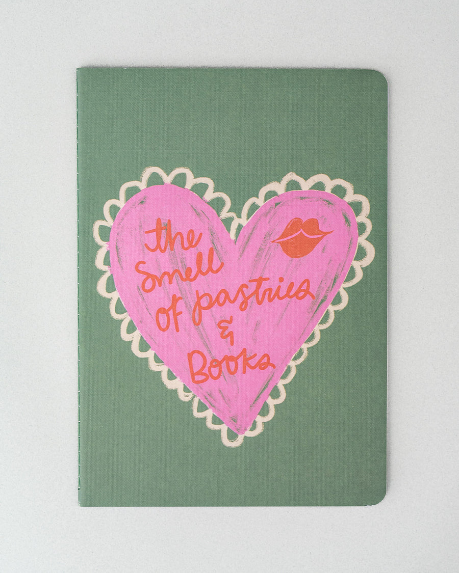 green notebook with pink heart and 'the smell of pastries and books'