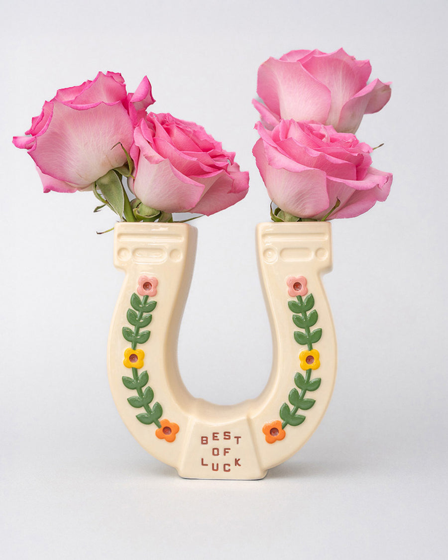 cream horseshoe ceramic vase with colorful flower trim and 'best of luck' stamp in the center with pink roses inside