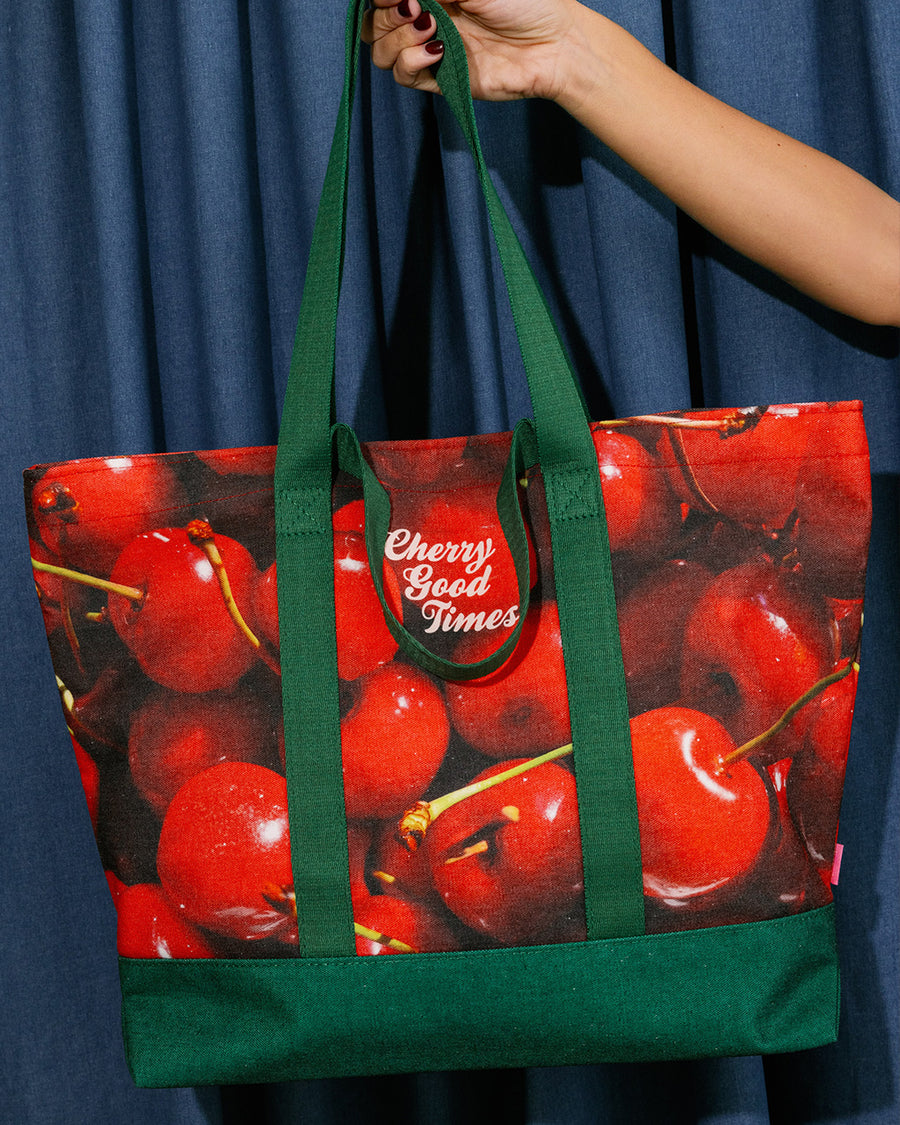model holding Large canvas tote bag with cheerful cherry print and says 'CHERRY GOOD TIMES'