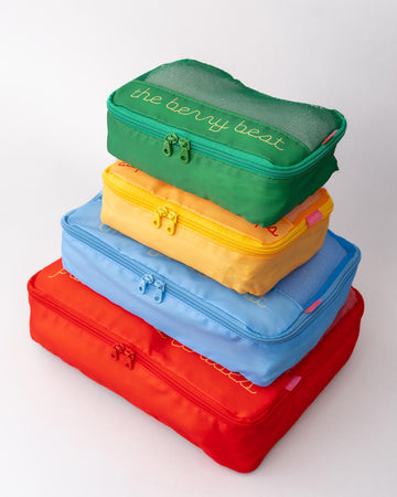 Side view of set of 4 packing cubes with various sayings and realistic prints