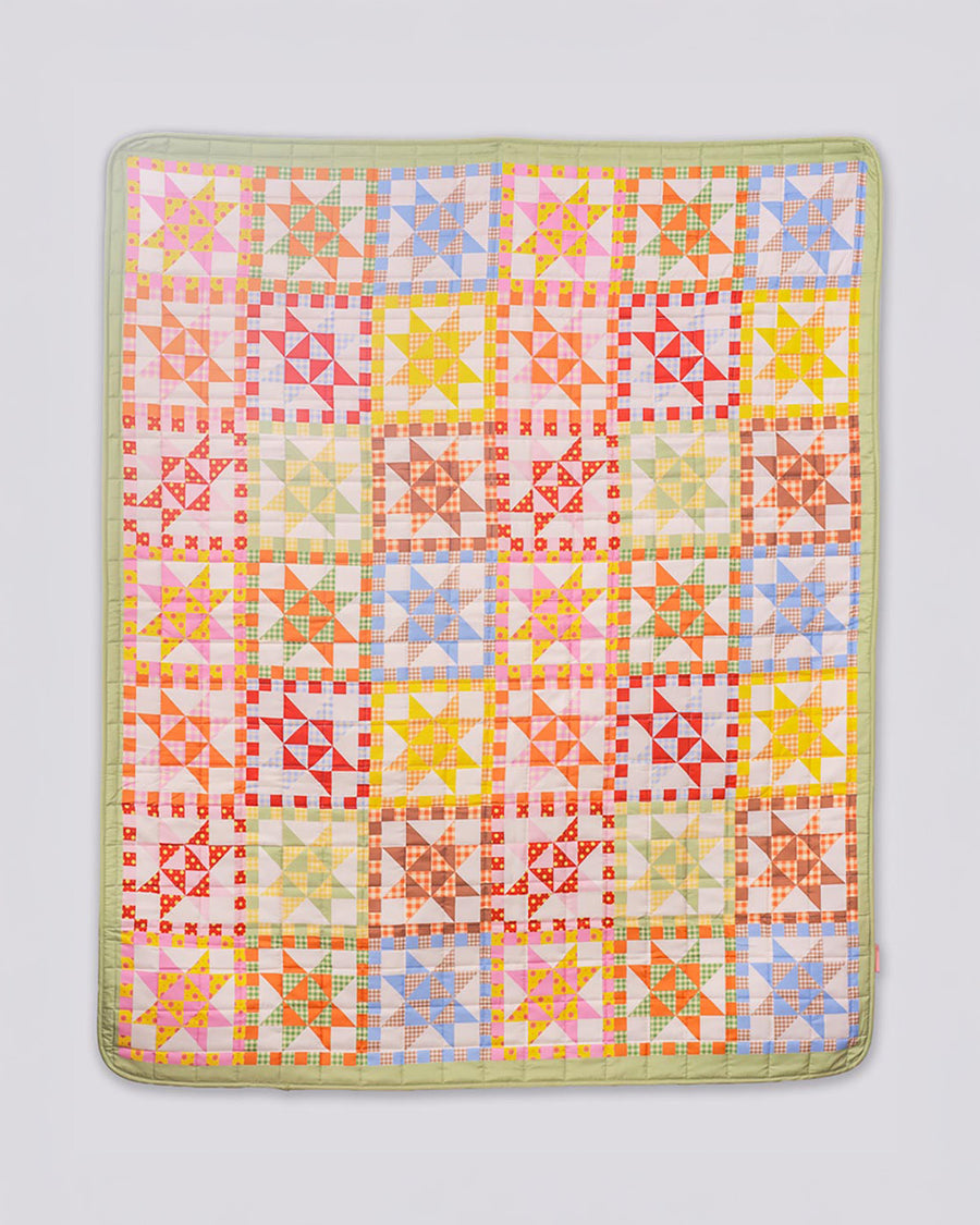 colorful patchwork print quilted blanket  with light green trim