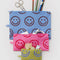 set of 3 flat pouch set: small yellow with periwinkle smiley, medium hot pink with bright smiley, and large light blue with brown smiley with items inside
