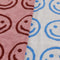 up close of set of smiley hand towels: light blue with blue smiley, pink and red smiley