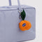 orange shaped bag charm on a lavender bag