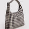 side view of black and cream gingham nylon shoulder bag