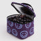 silver interior of plum puffy lunch bag with periwinkle smiley print and black zipper and handle with dark cherries inside