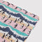 up close of pink, orange and teal puffy picnic blanket with penguin print