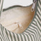 interior pocket of green and white vertical stripe small meringue bag with thick twist strap