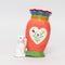 pink folk floral vase with a white cat 'tipping' it over