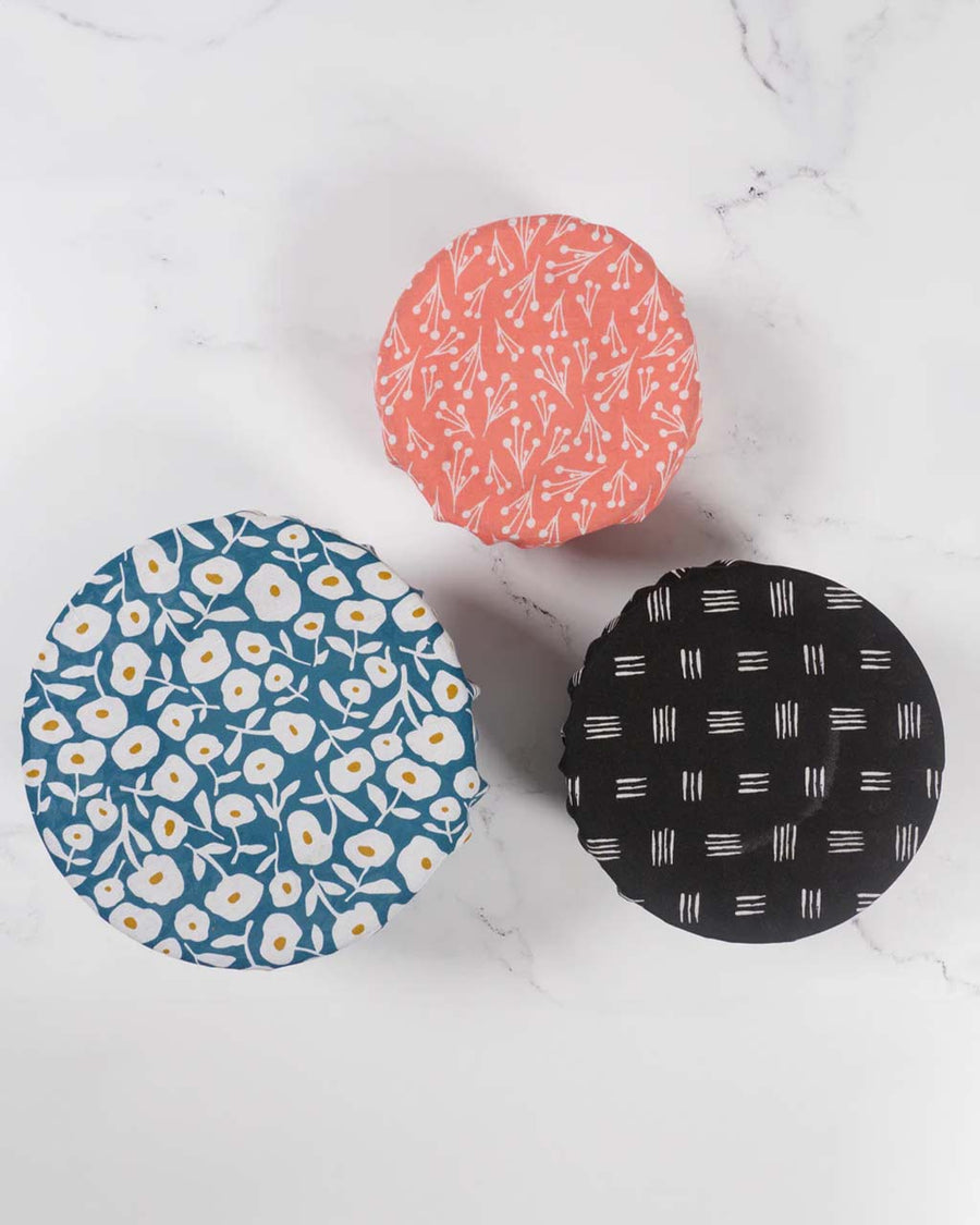 set of three reusable bowl covers. large: blue and white floral, medium: black and white lines, and small: pink and white dainty floral on three different sized bowls