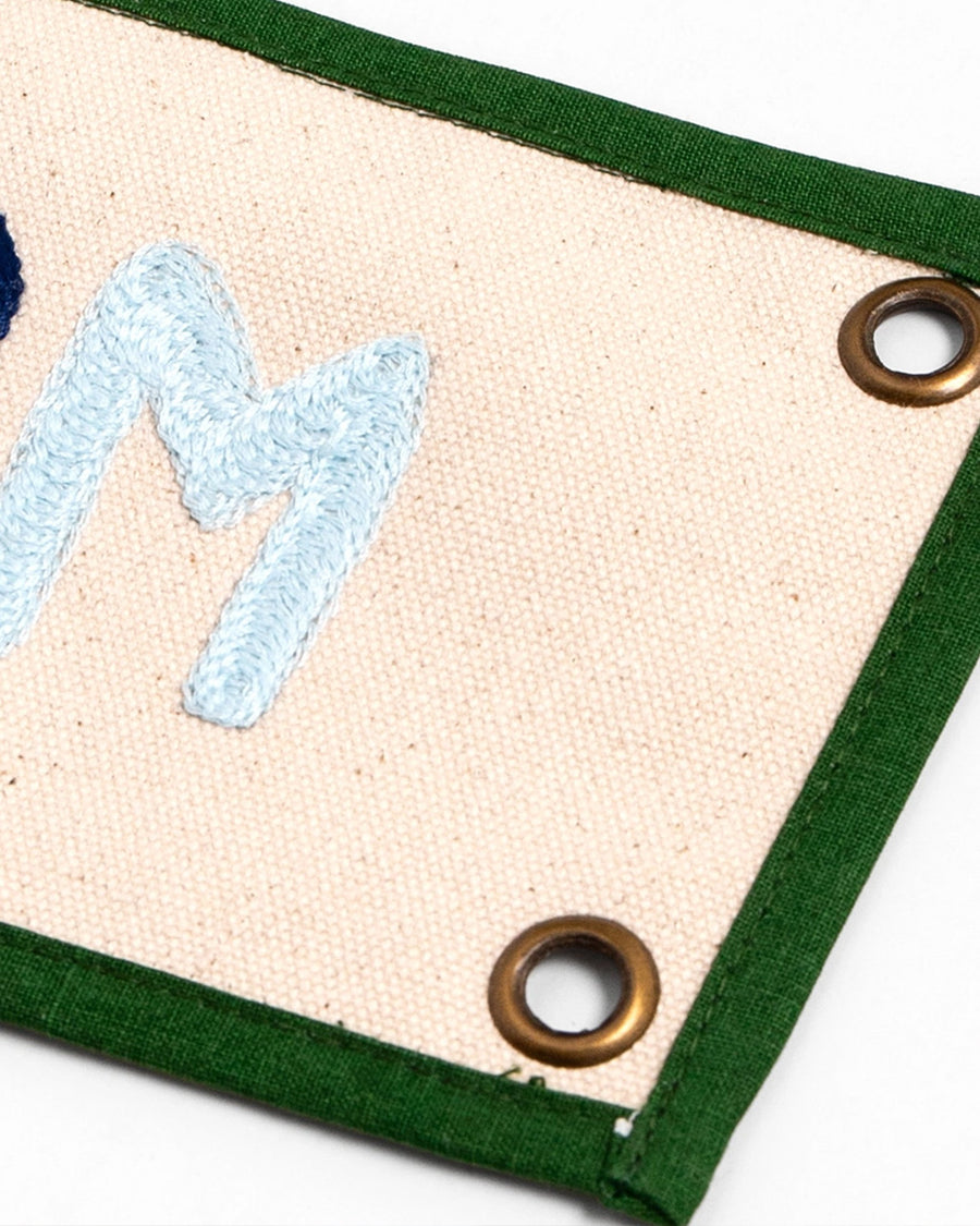 up close of grommets on canvas banner with rainbow 'bookworm' across the front and kelly green border