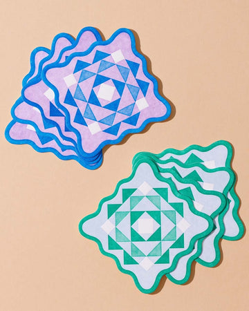 set of 8 letterpress coasters with purple and blue scalloped kaleidoscope and green and light blue scalloped kaleidoscope (4 of each)