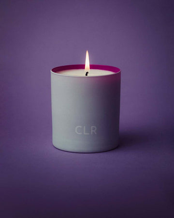 lit white candle with purple interior