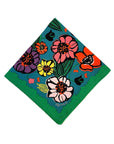 blue napkin with colorful abstract floral print with green trim along the edges