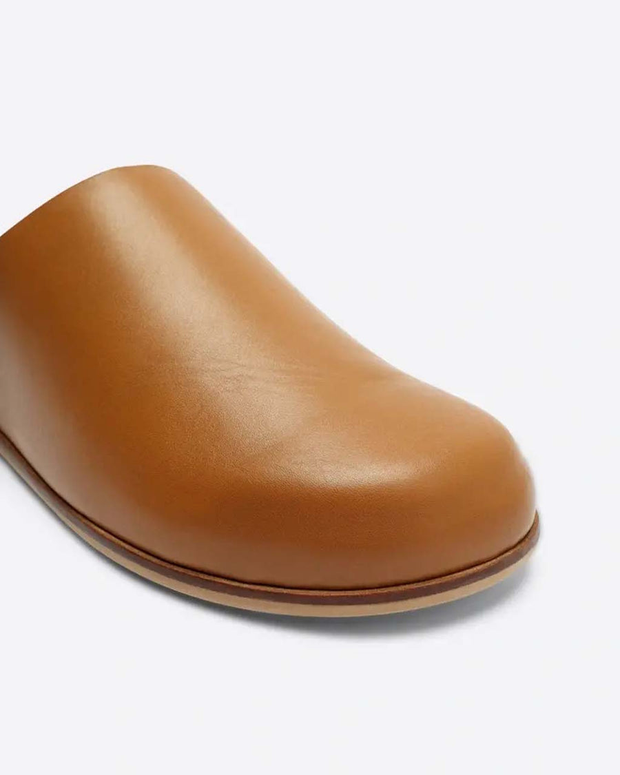 up close of brown leather slip on mules with a natural sole