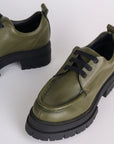 up close of olive green leather tie shoes with black lug sole