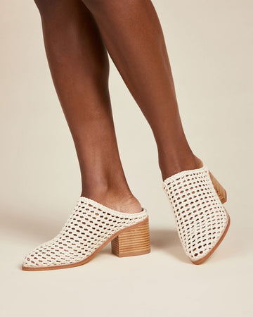 model wearing bone woven mules with stacked heel