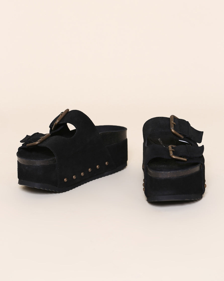 black suede platform slide sandals with oversized buckles and grommets