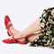 model wearing cherry red slingback flat with large grommet buckle and square toe