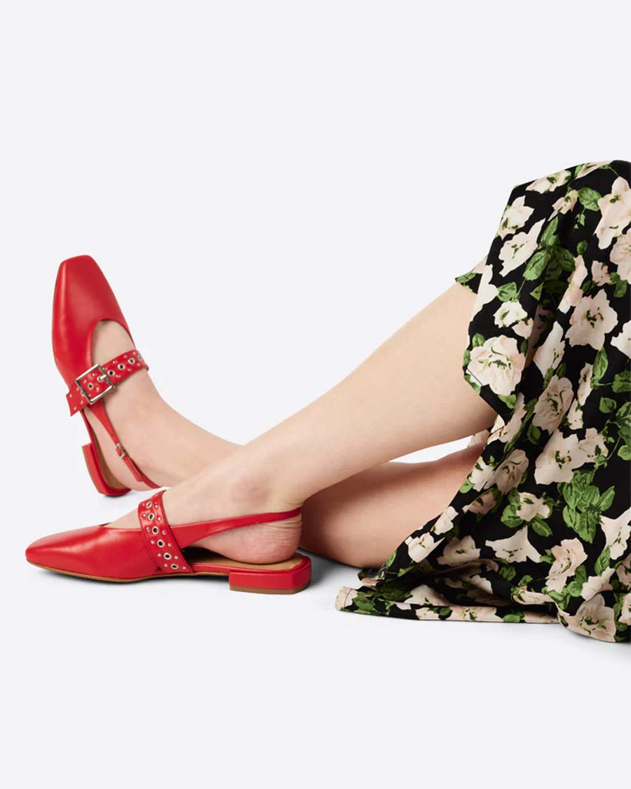 model wearing cherry red slingback flat with large grommet buckle and square toe