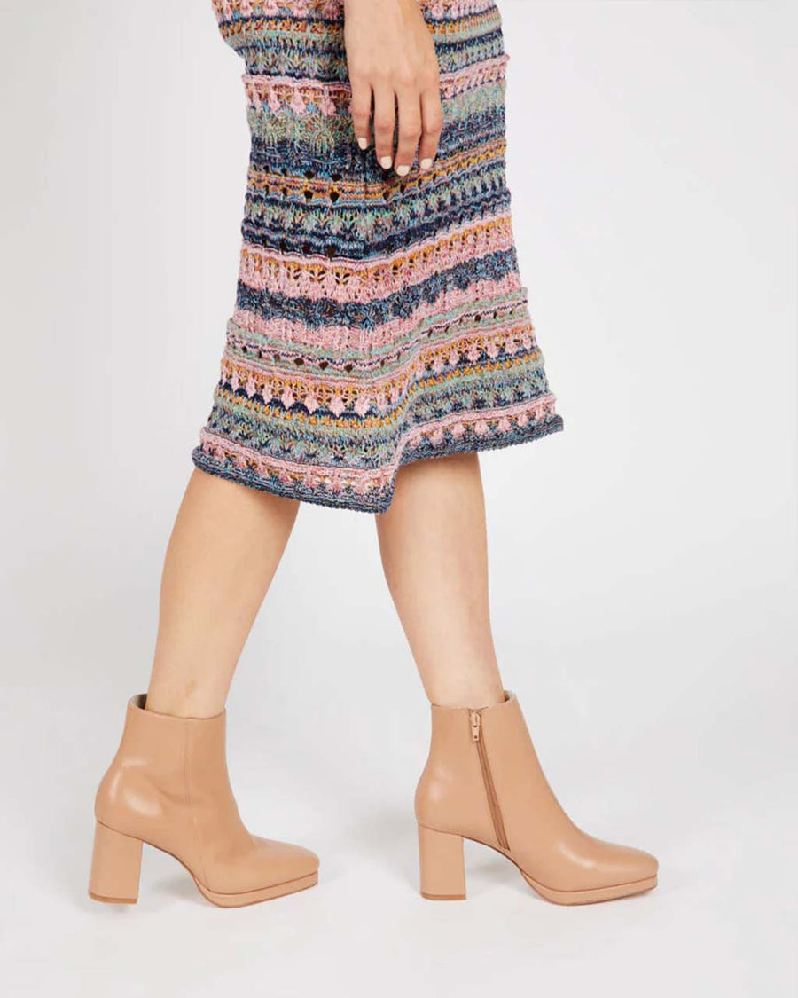 model wearing tan heeled side zip boots