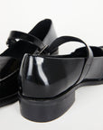 back heel on black shiny leather loafer shoe with buckle and strap