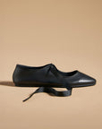 side view of black ballet inspired flats with tie laces and pointed toe