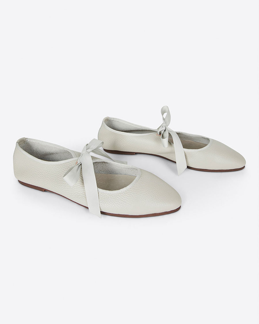 sideview of cream ballet shoes inspired flat with pointed toe and tie