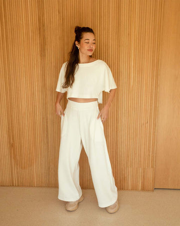 model wearing off white cropped short sleeve top and matching wide leg pants